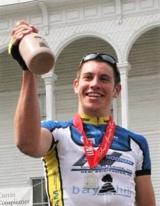 Ben holding a trophy after winning a professional cycling race