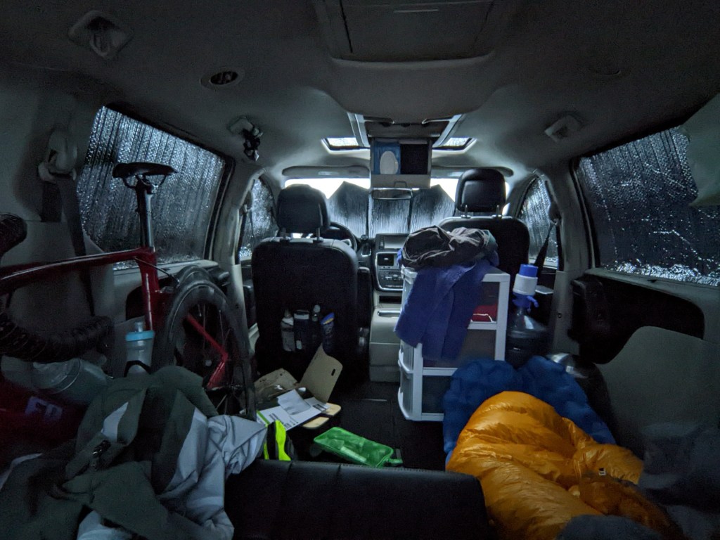 inside of a van with a sleeping bag and a bike