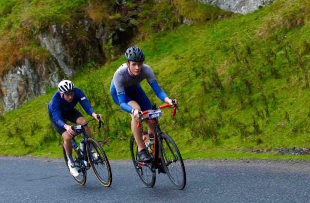Ewan Mackie cyclist riding up a hill with a friend