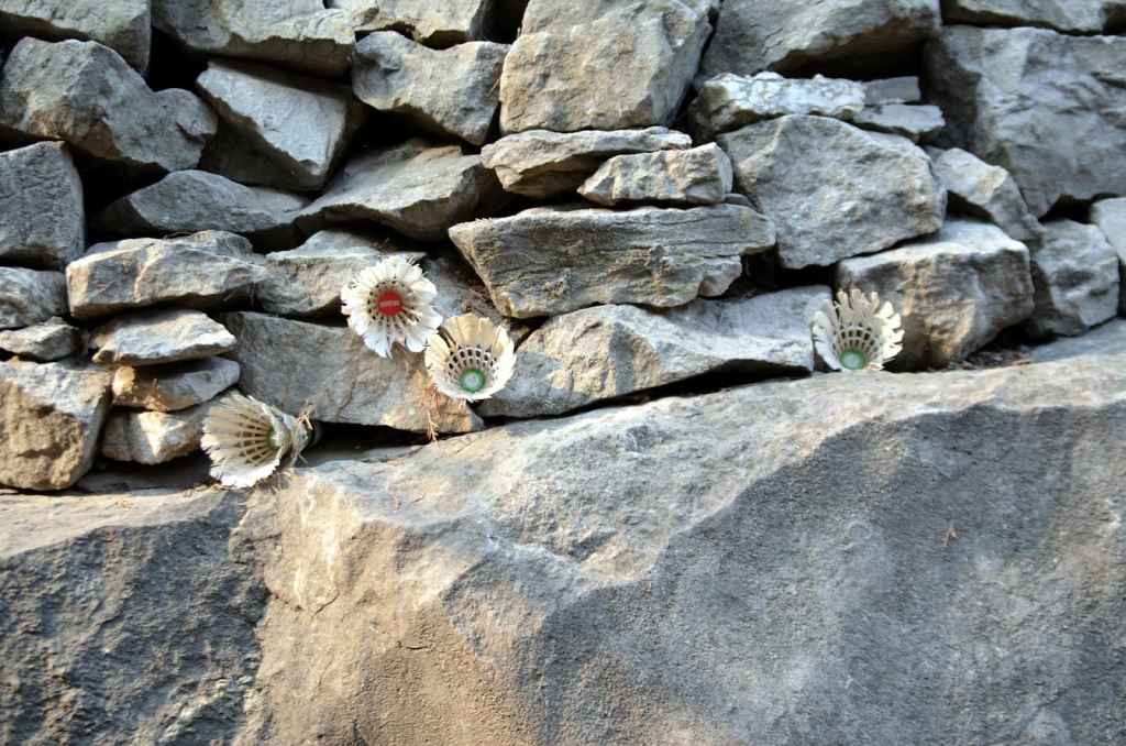 badminton birdies stuck in a brick wall