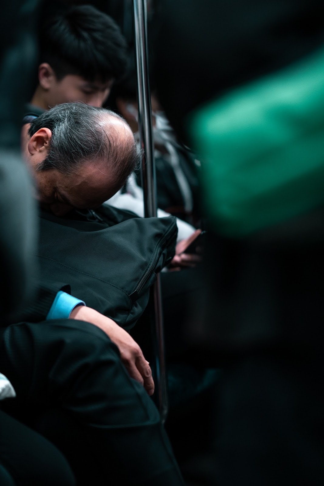 man sleeping sitting up on subway